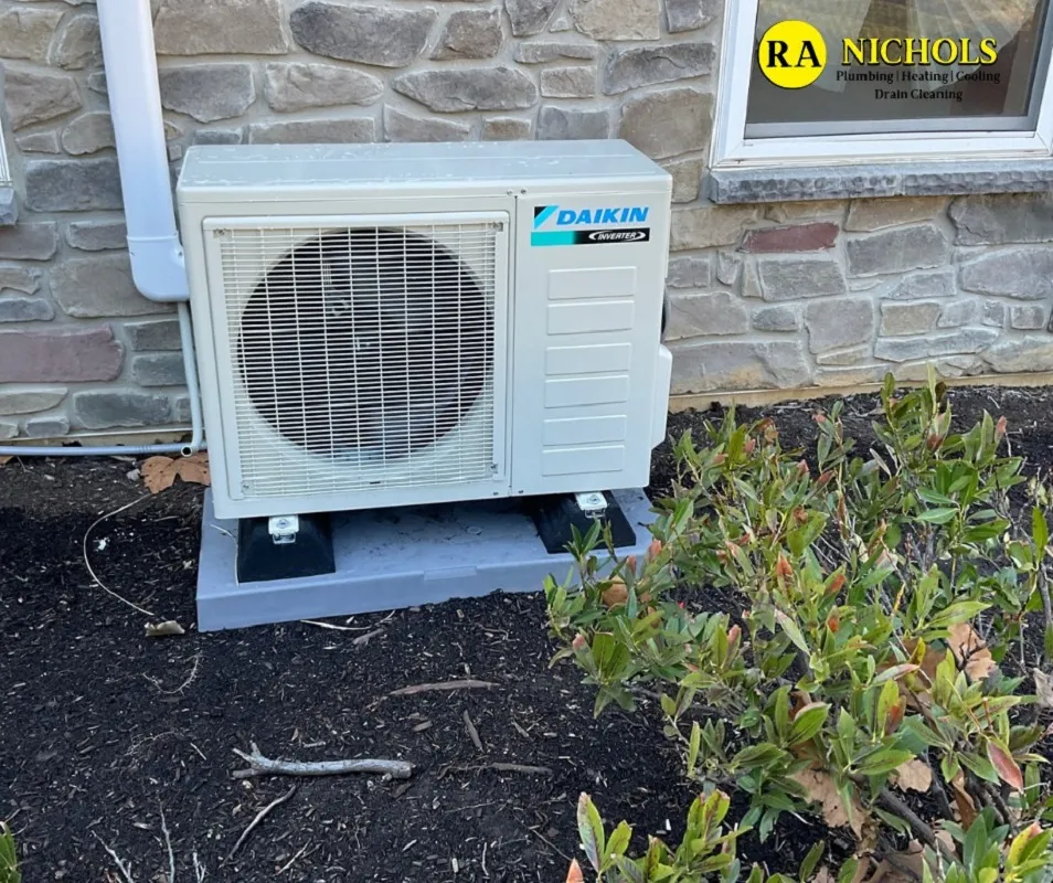 Outdoor Daikin air conditioning unit next to a stone wall